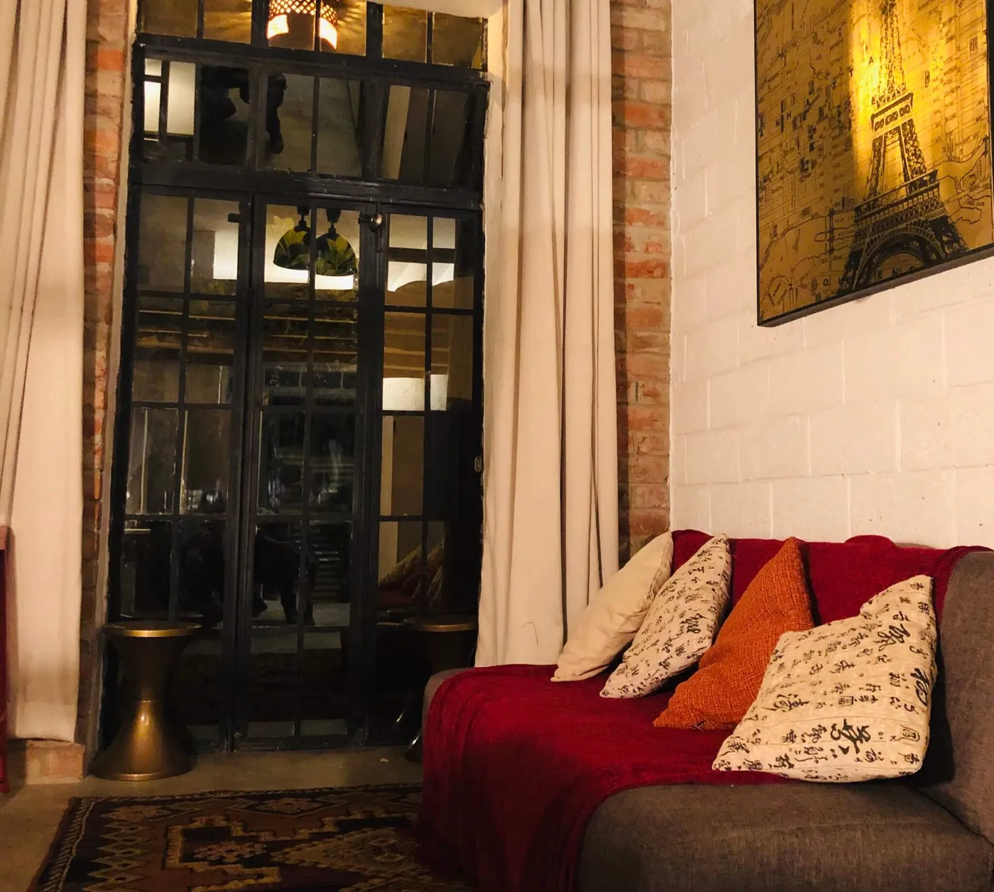 Inside an OSK studio: a sofa in a bright living area beside a glass door.